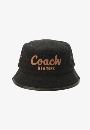 Schwarzer Stoff-Bucket-Hut mit braun gesticktem „Coach New York“-Logo vorne und kleinen braunen Ösen an den Seiten.