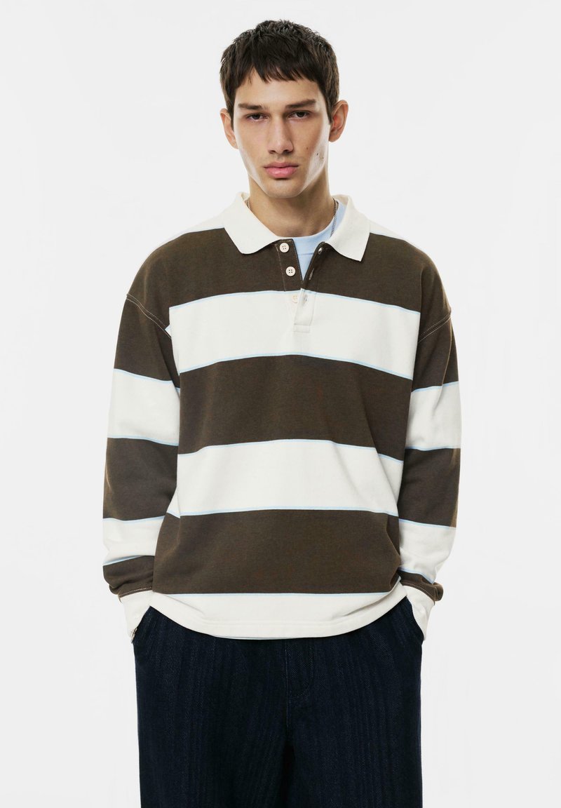 Długi rękaw polo w ciemnobrązowe i białe paski z delikatnym niebieskim akcentem, z trzema guzikami przy kołnierzyku i ściągaczami przy rękawach.