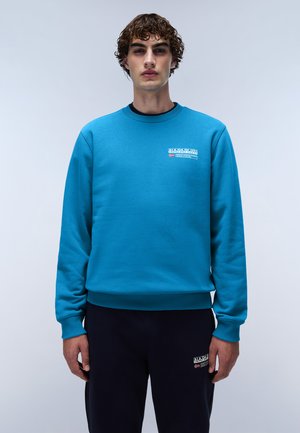 Blauwe sweatshirt gemaakt van fleece, met een ronde hals, ribgebreide mouwen en een logo op de borst. Gecombineerd met marineblauwe broek. Eenvoudig ontwerp.