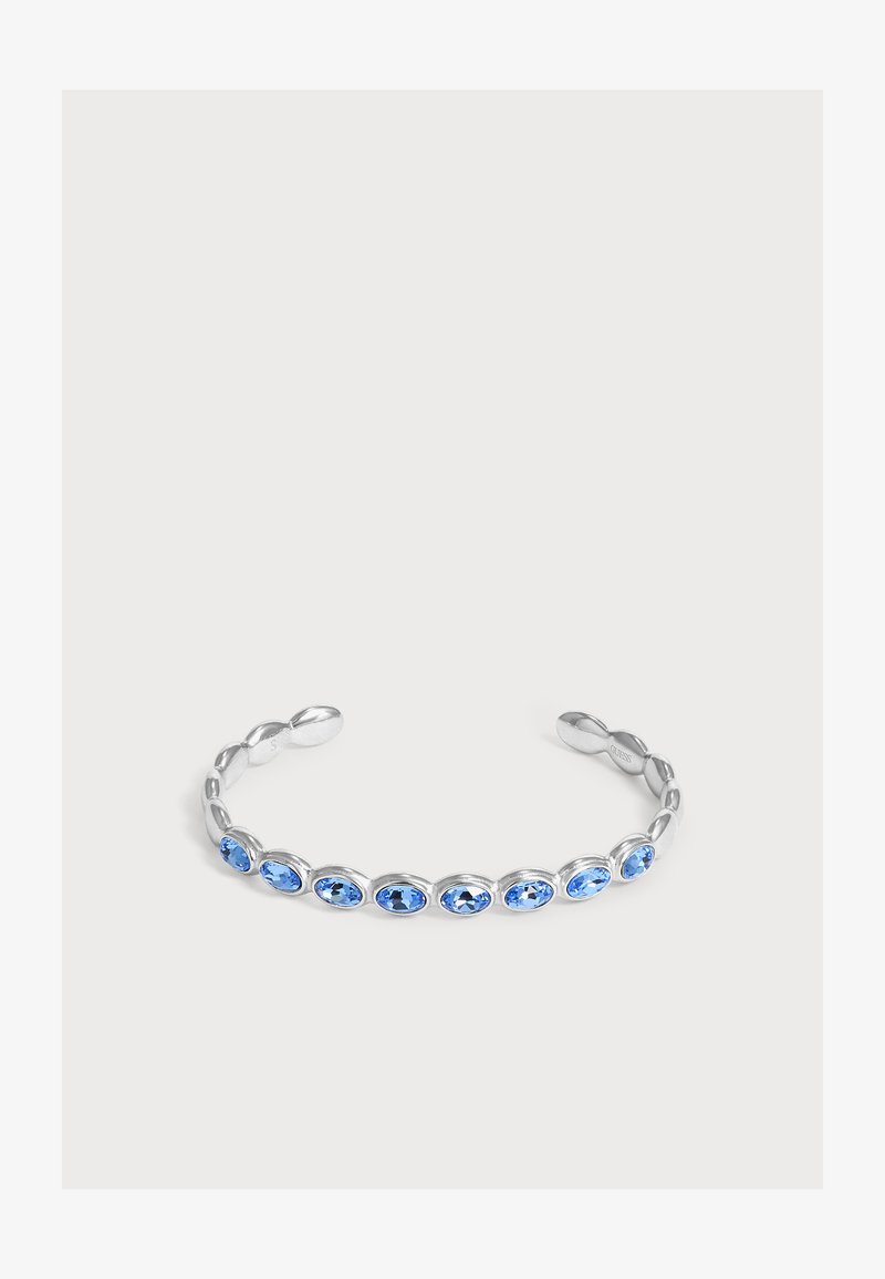 Bracelet manchette ouvert en argent avec des pierres précieuses ovales bleues régulièrement espacées sur le dessus.