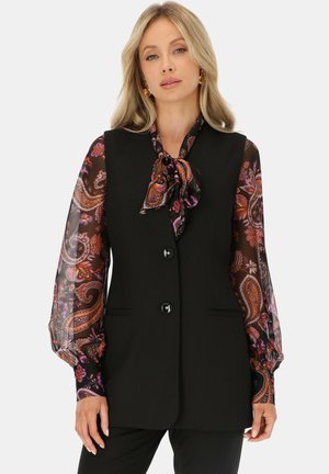 Czarna kamizelka o dopasowanym kroju z trzema guzikami, uzupełniona długimi, przezroczystymi rękawami w paisley w bogatych kolorach.