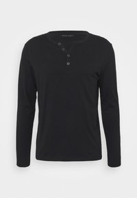 Camisa henley negra de manga larga, hecha de un tejido suave, con una placket de botones, cuello redondo y mangas ajustadas.