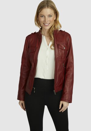 Rote Lederjacke mit Reißverschluss vorne, zwei Brusttaschen, Schultereppiletten und glatter Textur, getragen über einer weißen Bluse und schwarzen Hosen.