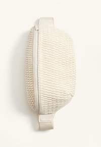 Geantă din material textil împletit, crem, cu suprafață texturată, închidere cu fermoar și mânere laterale. Formă compactă ovală, potrivită pentru organizarea cosmeticelor.