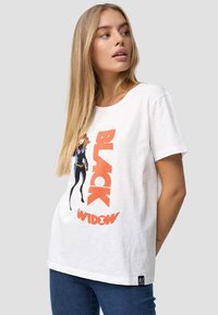 Hvid bomulds t-shirt med et grafisk motiv af en karakter i sort jakkesæt med teksten "BLACK WIDOW" i fede orange bogstaver.