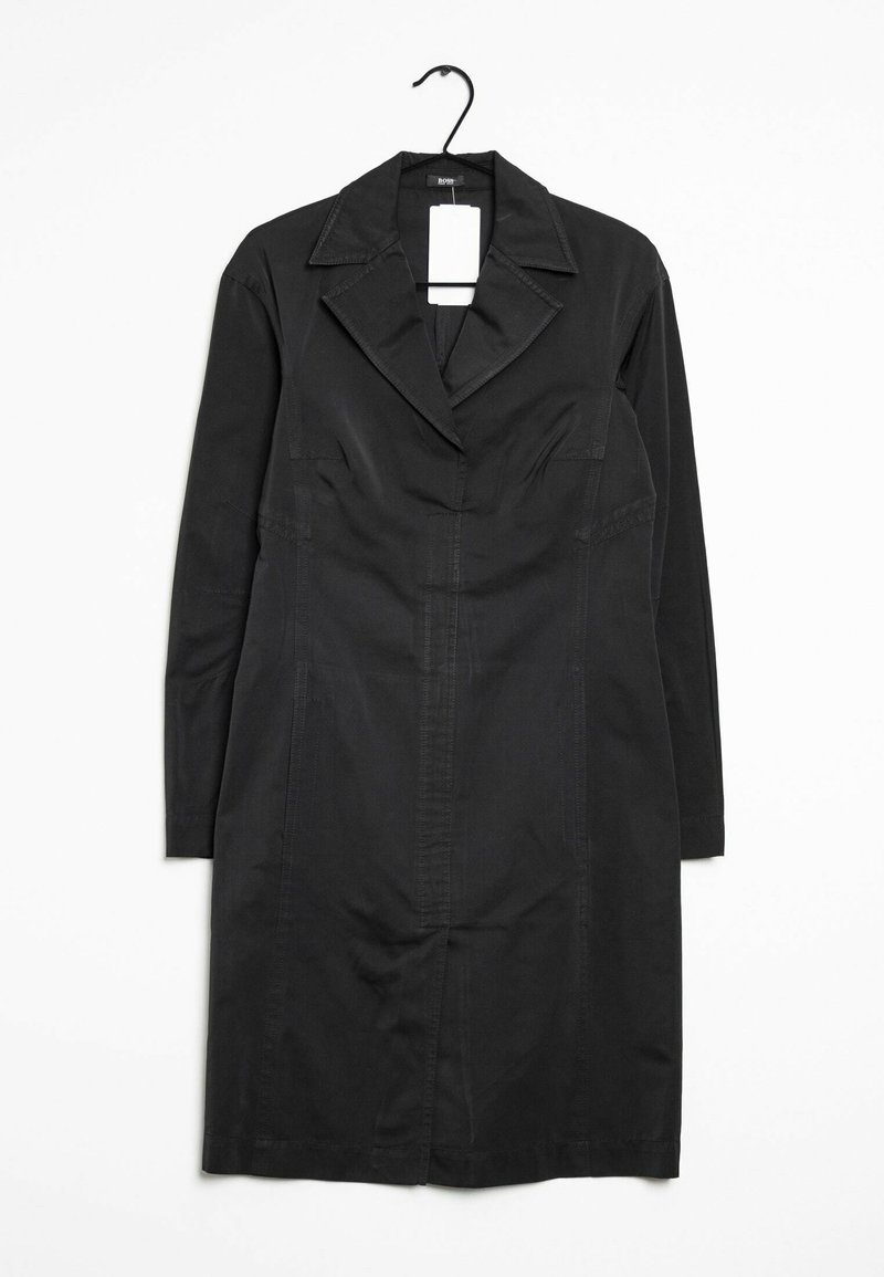Vestito nero a maniche lunghe con colletto a punta, chiusura frontale con bottoni, due tasche laterali e cuciture verticali per una maggiore struttura. Realizzato in tessuto intrecciato.