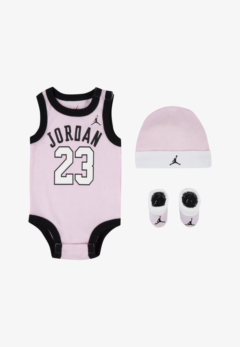 Macacão de algodão rosa com contornos pretos, exibindo "JORDAN" e "23" em branco. Inclui um chapéu rosa a condizer e botinhas com detalhes pretos.