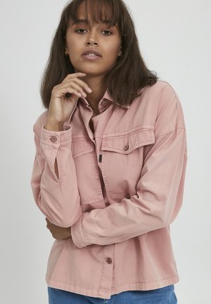 Pink long-sleeve shirt with button closure, two chest pockets, and collar. Made of textured fabric with a relaxed fit.