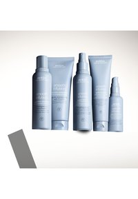 Aveda Smooth Infusion haarverzorgingsproducten in lichtblauwe verpakking, met een verscheidenheid aan flessen en tubes met gladde, afgeronde vormen en duidelijke labeling.
