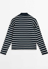 Camicia a righe bianca e nera a maniche lunghe con colletto alto, stesa su un piano a mostrare il lato posteriore.