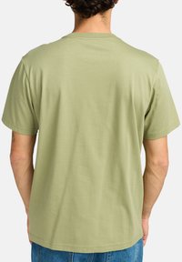 Olivenfarvet bomulds T-shirt med korte ærmer, rund halsudskæring og en glat overflade. Simpelt design uden synlige mønstre eller tryk.