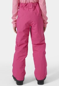Růžové sněhové kalhoty s volným střihem, vysokým pasem a zesílenými lemy, vyrobené z voděodolného materiálu.