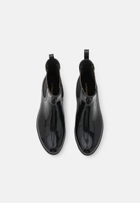 Zwarte glanzende enkelboots met een soepele textuur, elastische zijpanelen en trekbanden voor gemakkelijk aan- en uittrekken. Rond neu, en duurzame rubberen zool.