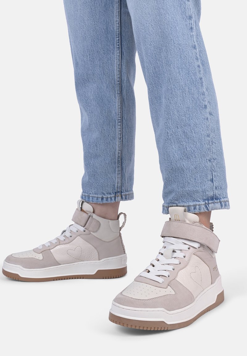 Beige und cremefarbene High-Top-Sneaker mit einem herzförmigen Design, aus Wildleder und Leder, weißen Schnürsenkeln und Gummisohlen.
