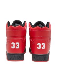 Baskets montantes rouges avec des accents noirs, présentant une surface extérieure en cuir lisse, le numéro blanc "33" à l'arrière, et "EWING" embossé sur la semelle.