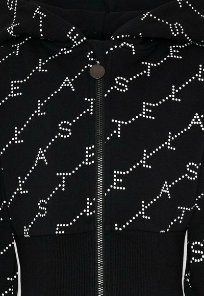 Felpa nera con zip e cappuccio, con motivo a pois bianchi che formano lettere diagonali sul tessuto, dotata di una chiusura lampo rotonda in metallo.