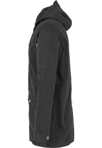 Giacca nera con cappuccio, zip frontale, numerose tasche e un tessuto testurizzato. Presenta dettagli con bottoni e un design a taglio dritto.