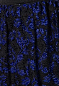 Tessuto di pizzo nero con un motivo floreale blu, caratterizzato da una superficie testurizzata e una cintura elastica, creando un aspetto a strati.