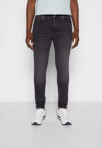 Slim-fit svarta denimjeans med en lätt blekning, med framfickor, knäppning och detaljerad sömnad på fickorna.