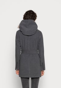 Abrigo gris con capucha que presenta una cintura con cinturón, mangas largas y bolsillos laterales con cremallera. La tela tiene una textura suave con un patrón sutil.