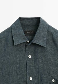Dark blue linen shirt featuring a classic collar, a front button closure with white buttons, and a single chest pocket.