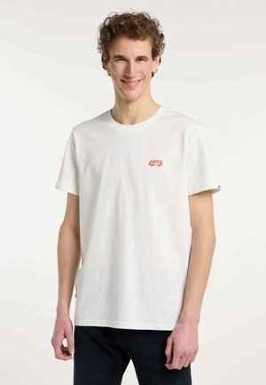 T-shirt en coton blanc avec un petit graphique d'une camionnette vintage rouge sur la poitrine. Manches courtes et design classique à col rond.