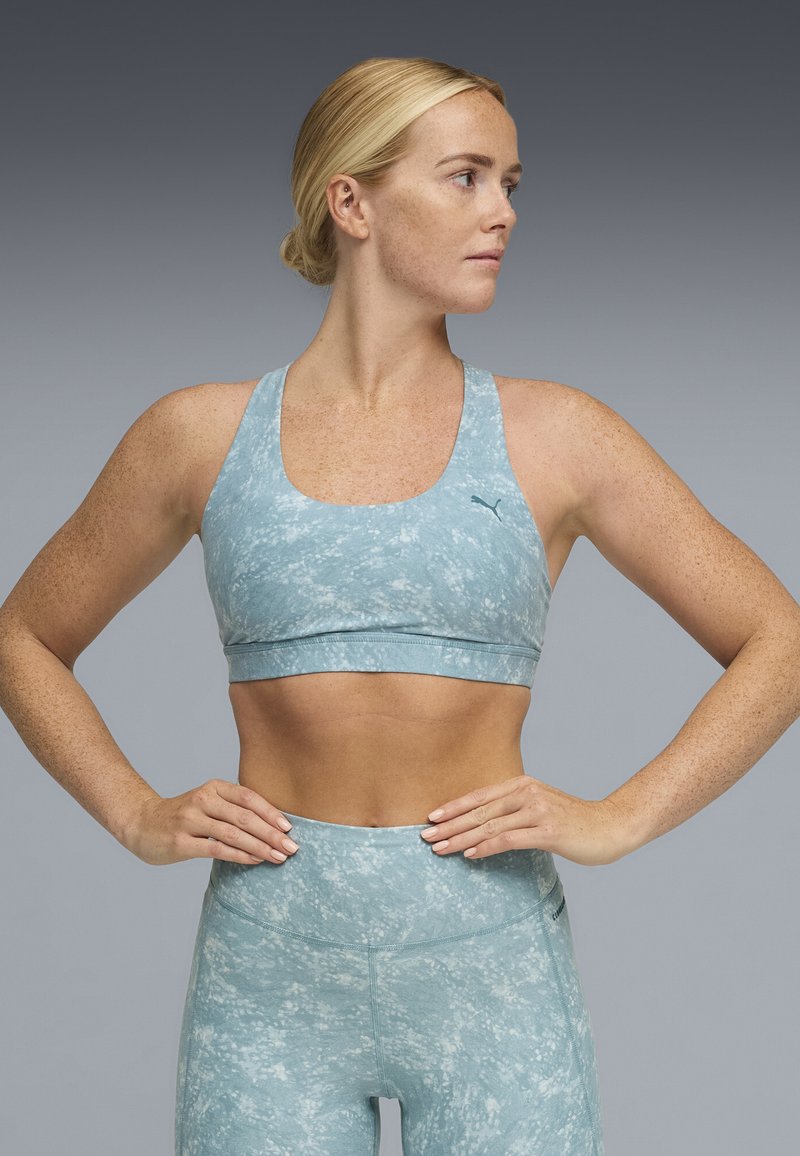 Ανοιχτό μπλε αθλητικό σουτιέν με υφασμένο μοτίβο, φαρδιές τιράντες και υποστηρικτική ζώνη, συνδυασμένο με αντίστοιχο κολάν ψηλής μέσης με παρόμοι ο σχέδιο.