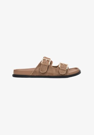 Brown faux fur slide sandals with two adjustable gold buckles, a smooth light brown footbed, and a black rubber sole.