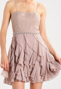 Fialové šaty s krajkovým korzetem a volánkovou sukní z šifonu. Obsahují korzet s perličkami a tenké ramínka.