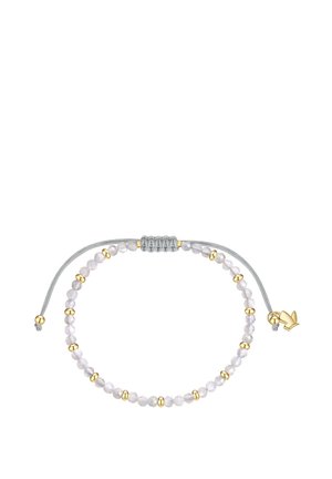 Bracelet ajustable avec des petites perles blanches et dorées alternées sur un cordon gris, avec un charm en forme d’oiseau doré près du nœud.