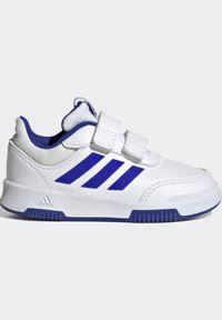 Zapatilla deportiva blanca con acentos azules, que cuenta con una parte superior de cuero suave, dos correas de Velcro y tres franjas azules contundentes en el costado.