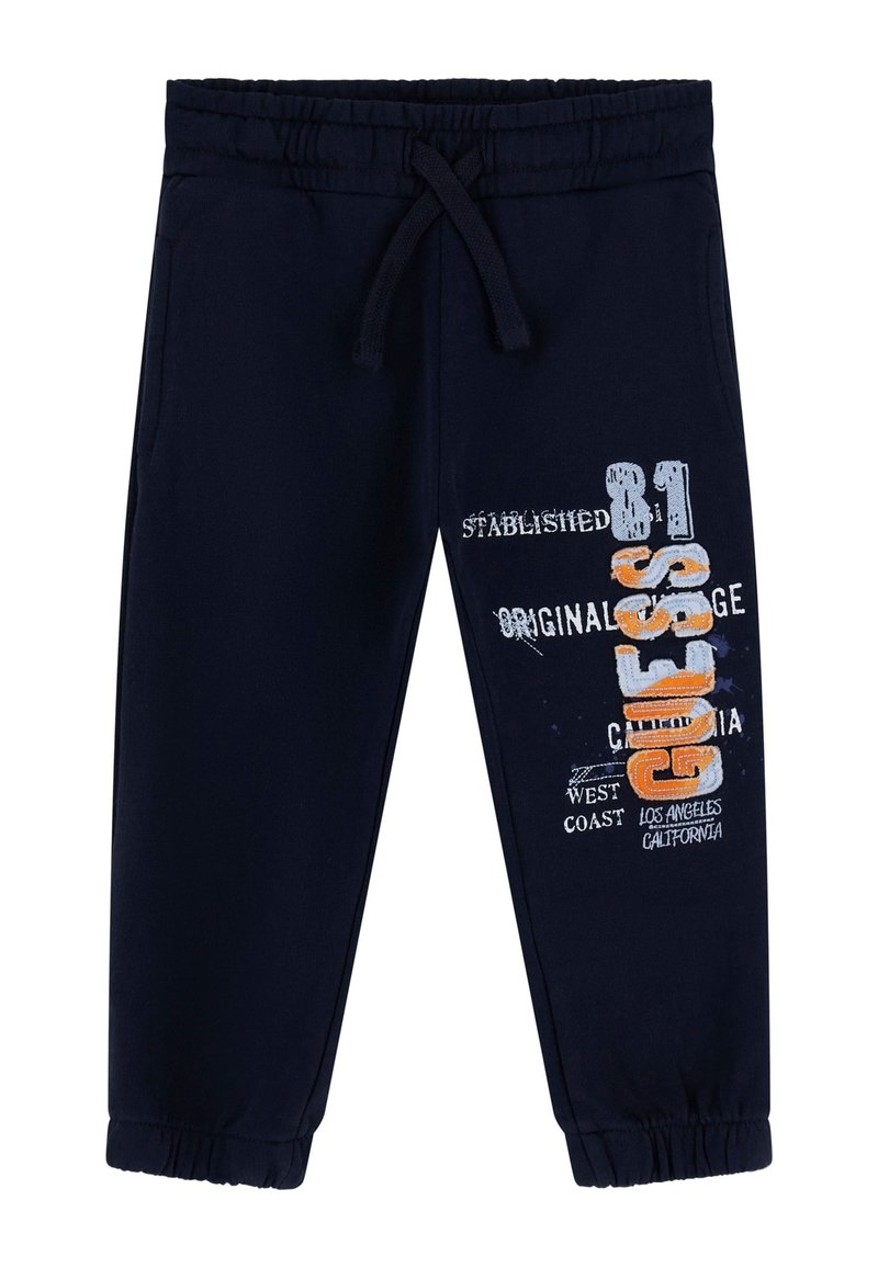 Pantalones de chándal azul marino con cintura elástica y cordón, con un diseño gráfico en blanco y naranja en la pierna izquierda.