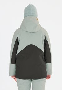 Vattentät jacka i ljusgrå och svart, med huva, som har en färgblockdesign och slät textur. Bärs med matchande byxor.
