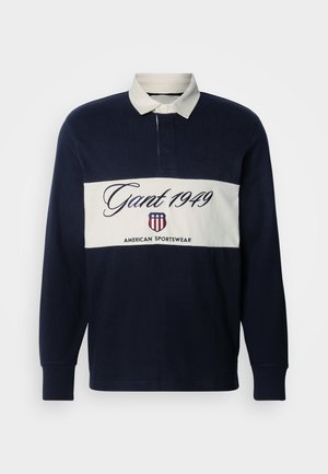 Granatowa polo z długim rękawem, z białym kołnierzykiem i poziomym białym pasem. Wykonana z logo "Gant 1949" oraz marką American Sportswear. Materiał z mieszanki bawełny.