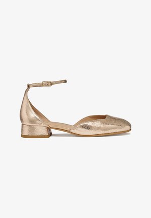 Zapato de tacón bajo en oro rosa metálico con punta cerrada y puntiaguda y fina correa en el tobillo con hebilla sobre fondo blanco.