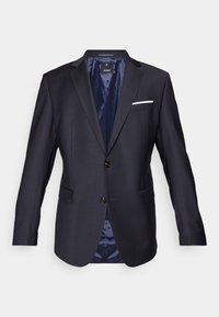 Navy blazer made from textured fabric, featuring a single-breasted design, two front pockets, a white pocket square, and a satin interior.
