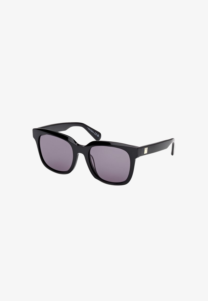 Gafas de sol cuadradas negras con lentes oscurecidos, con montura de plástico grueso y un sutil detalle de logo en las patillas.