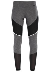 Szare legginsy z czarnymi siateczkowymi akcentami, z geometrycznym wzorem i białą lamówką poniżej kolana, wykonane z elastycznego materiału.