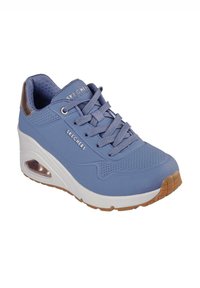 Zapatilla azul con parte superior sintética texturizada, perforaciones para transpirabilidad, media suela blanca y suela de goma marrón claro. Presenta un talón acolchado.