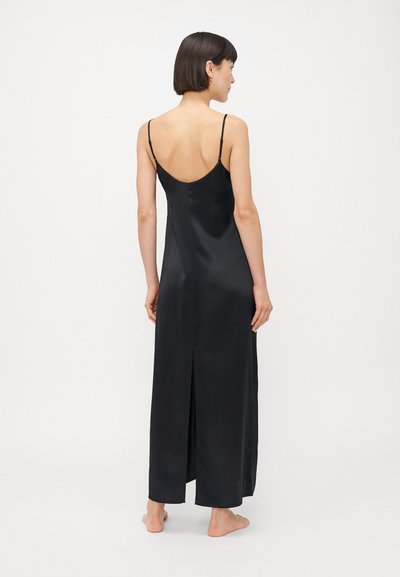 Musta satiinihihaton mekko, jossa on ohuet olkaimet, matala selkä ja sivu-aukko. Sileä pinta ja täyspitkä muotoilu korostavat sen eleganttia ulkonäköä.