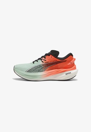 Chaussure de course Puma avec une tige en mesh de couleur vert menthe et corail, présentant des accents noirs, une semelle intermédiaire blanche rembourrée et une semelle extérieure noire texturée.