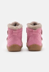 Bottines à chevilles en daim rose avec une douce doublure en fourrure, couture renforcée et semelle en caoutchouc naturel. Équipées de deux sangles réglables sur les côtés.