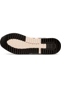 Semelle en caoutchouc noir avec des stries texturées et une semelle intermédiaire beige. La semelle extérieure présente un motif segmenté pour une meilleure adhérence et durabilité.