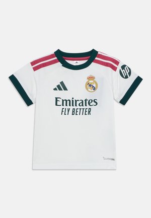 Camiseta de fútbol blanca del Real Madrid con cuello y bordes de las mangas en verde oscuro, rayas rosas en los hombros, logotipos de Adidas y HP, y texto "Emirates Fly Better".
