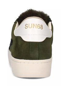 Sneaker verde in suede con tallone bianco che presenta "SUN68" in lettere dorate, texture morbida e suola in gomma. Senza lacci visibili.