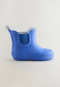 Mėlynas guminis kulkšnies batai su tekstūruota paviršiaus, turintis audinio panelę ir kilpą gale. Žvyrinė padas dėl sukibimo.