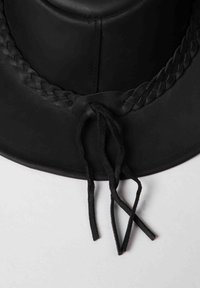 Black rubber hat with a wide brim, featuring a braided band and two adjustable ties. Smooth texture with matte finish.
