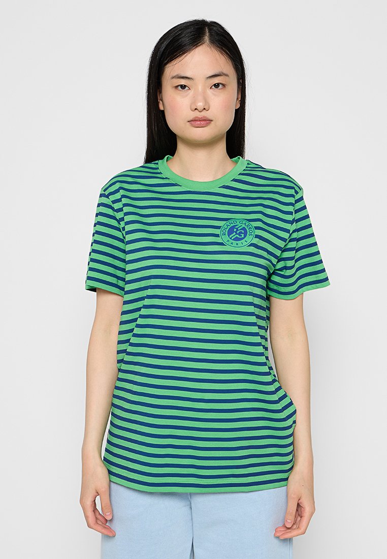 T-shirt a maniche corte a righe verdi e navy con scollatura rotonda, presenta un logo circolare sulla parte sinistra del petto. Tessuto morbido.