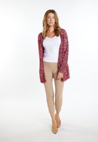 Cardigan roșu texturat cu front deschis, purtat cu o cămașă albă și pantaloni slim-fit bej. Întregul ansamblu este completat cu pantofi cu toc nude.
