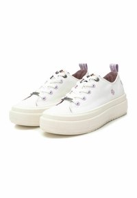 Zapatillas de lona blancas con una suela gruesa y texturada. Presentan acentos en color lavanda y un bordado de flores en el costado. Diseño de punta redonda.